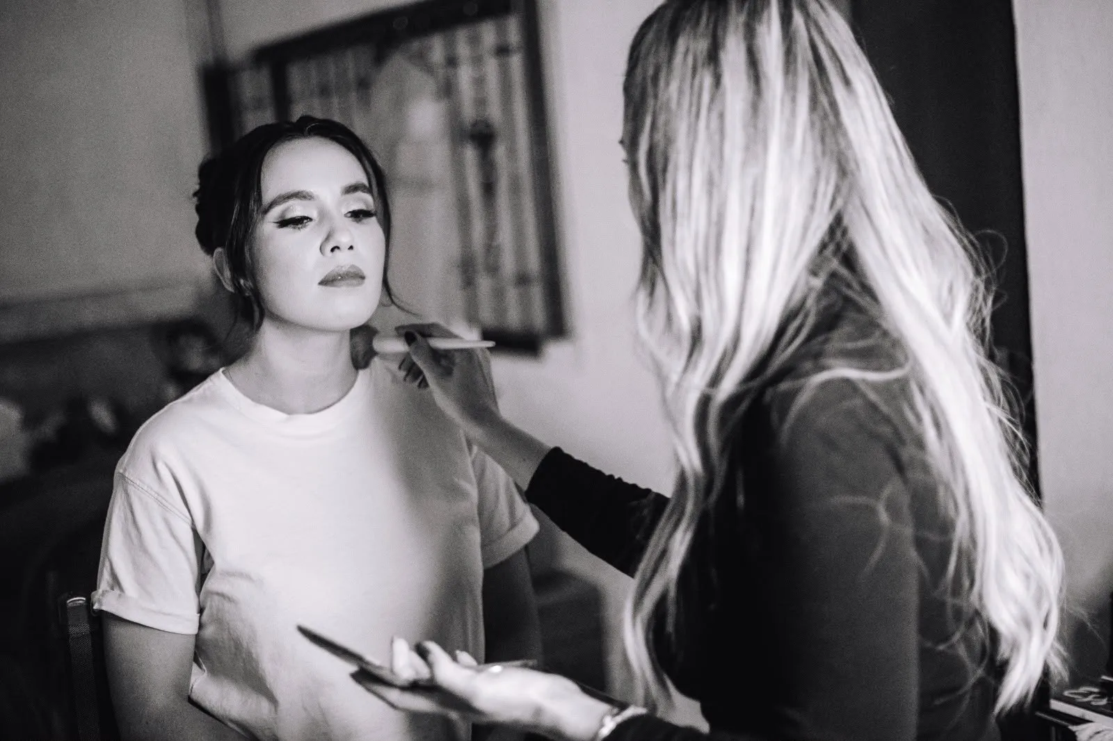 Janette Fonseca maquillando a una clienta, fotografía en blanco y negro