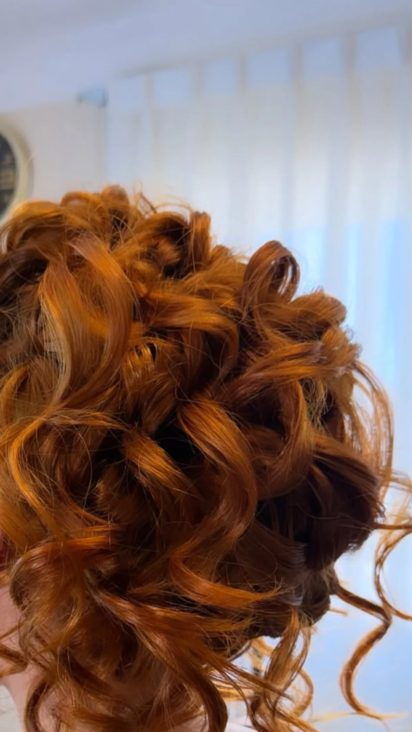Updo de rulos voluminosos en cabello pelirrojo