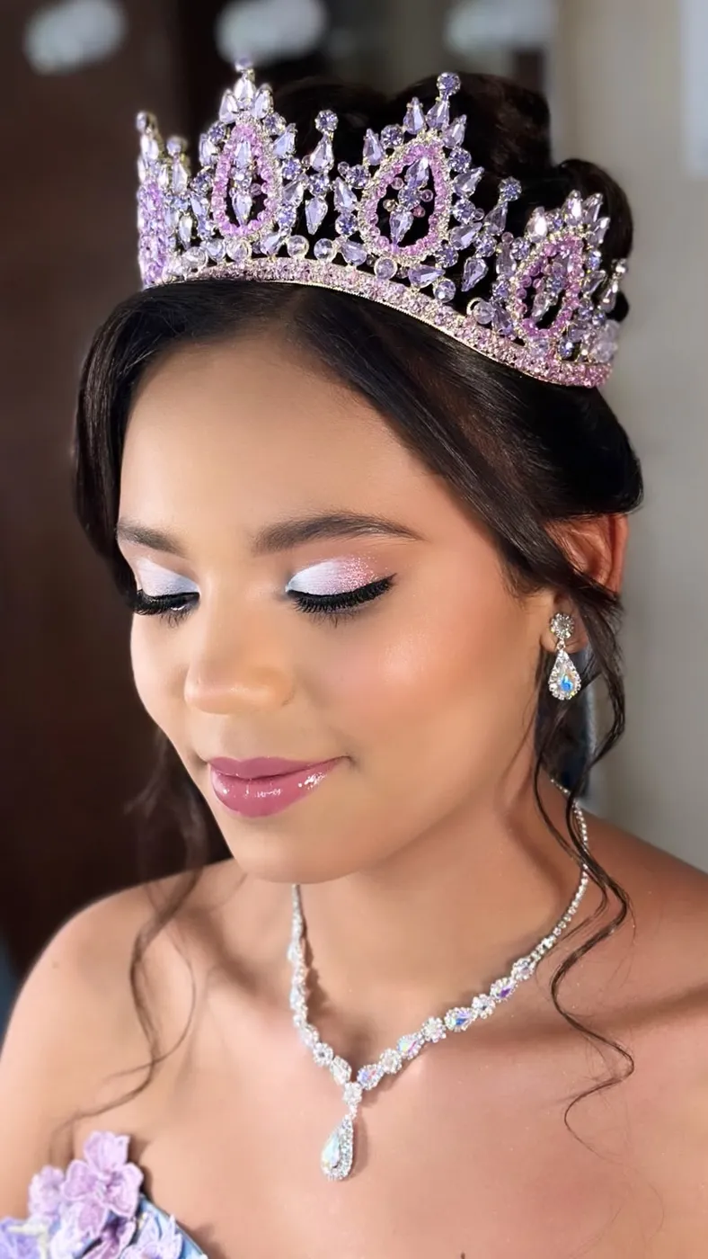 Quinceañera con corona lila y maquillaje con glitter